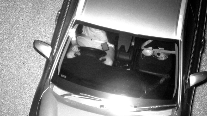 Man used mobile phone while driving in black and white image taken by new camera.