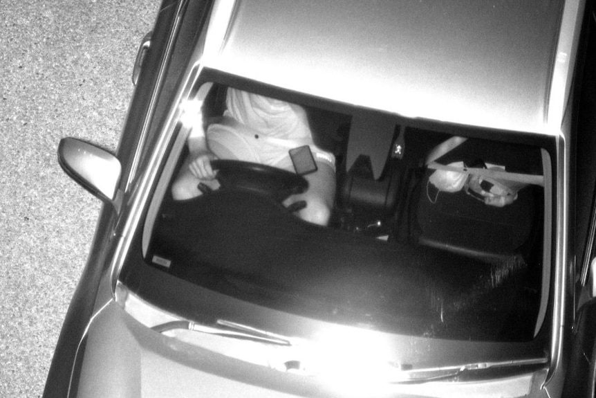 Man used mobile phone while driving in black and white image taken by new camera.