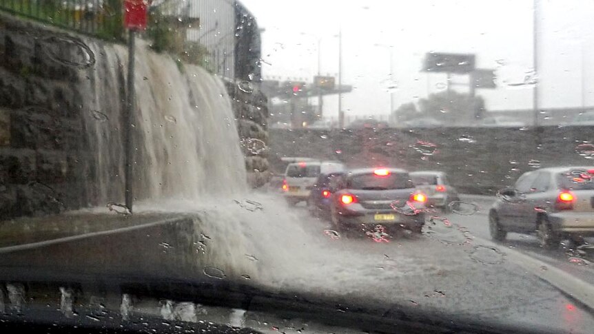 Water pours onto the road at one of the approaches to the Sydney Harbour Bridge.