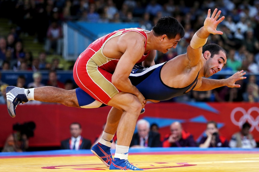 Roman Vlasov (L) wrestles Arsen Julfalakyan during their greco-roman 74 kg gold medal bout.