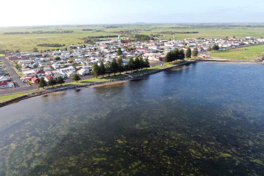 A drone shot of a coastal town next to the ocean. 