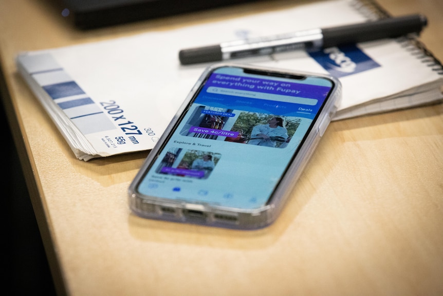 A phone with the screen on, resting on the table.