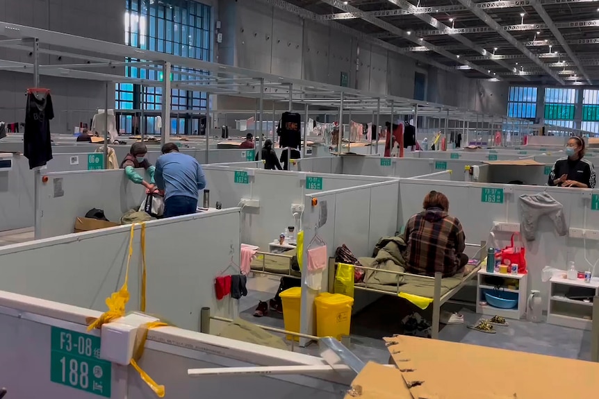 Residents rest at the brightly-lit quarantine facility