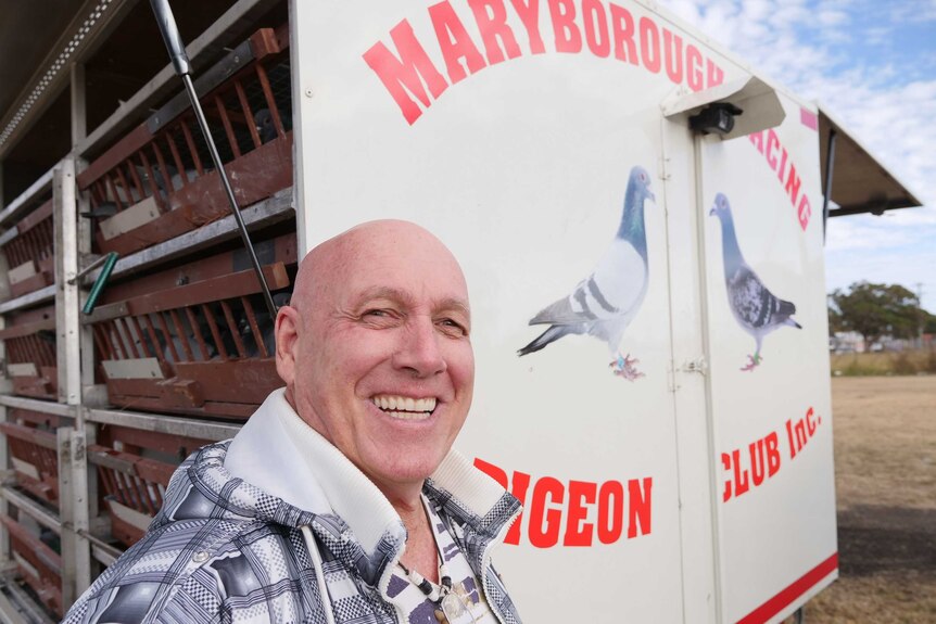 George Simpson stands beside Maryborough Racing Pigeon Club trailer containing hundreds of racing pigeons.