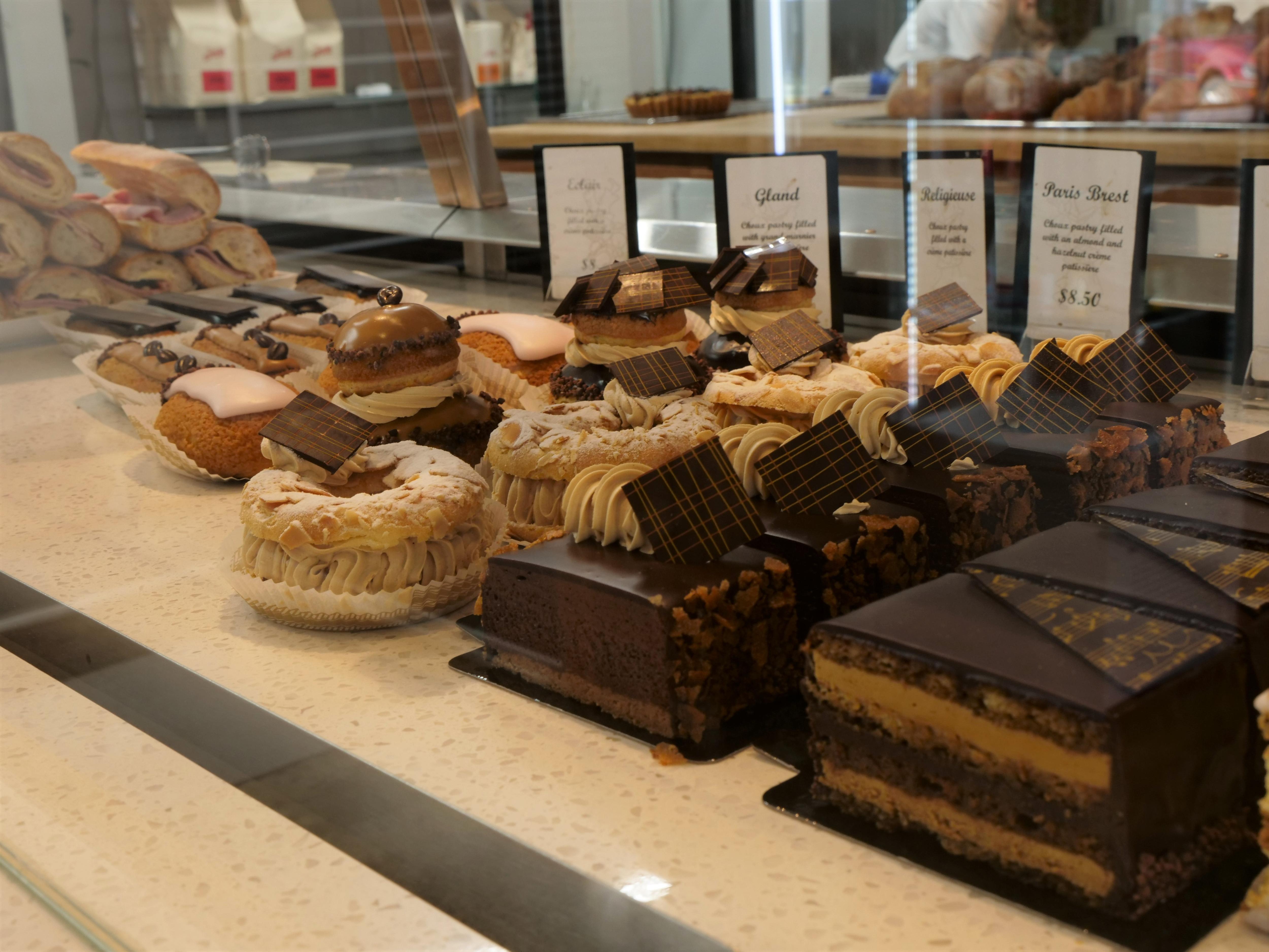 row of french pastries and baguettes inside cabinet at store