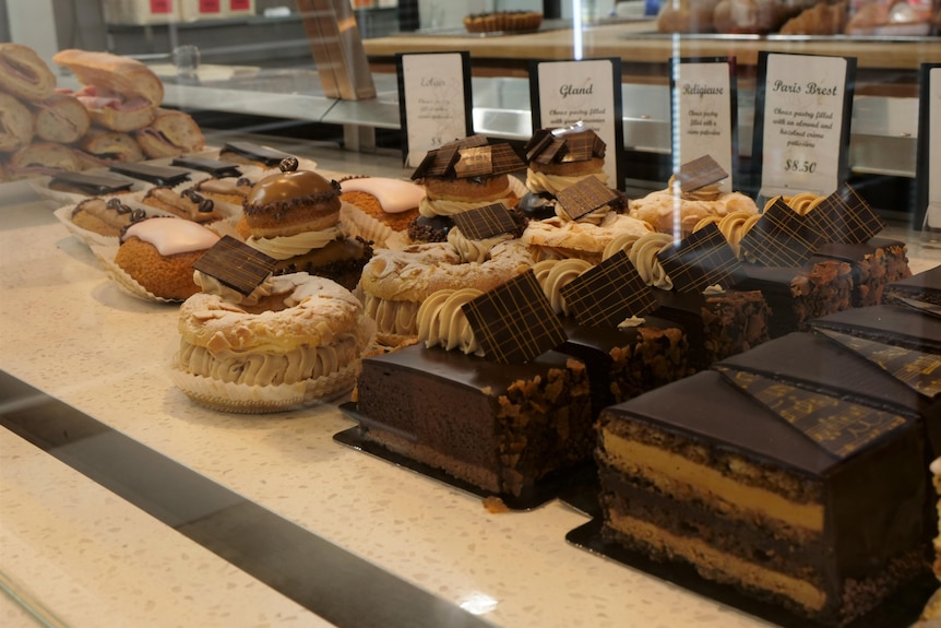 row of french pastries and baguettes inside cabinet at store