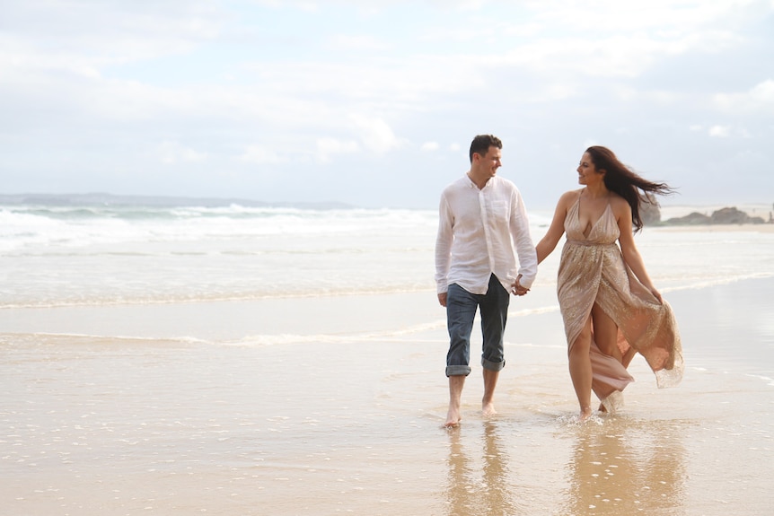 Happy couple walking along a beach