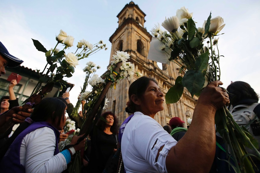 Women holding white flowers.