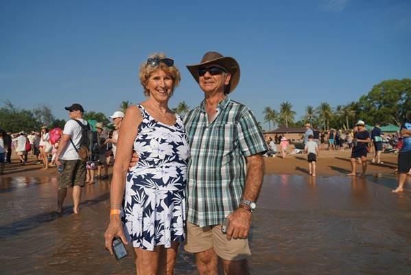 Two people standing on the beach.