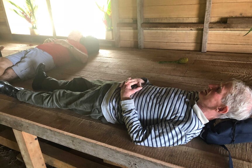 Craig Berkman and Sean Dorney lying on wooden floor.