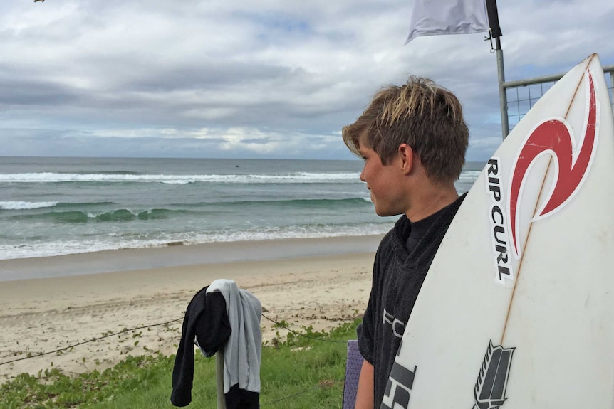 15-year-old Morgan Cibilic looks at the surf ahead of his heat at the Oz Grom Open at Lennox Head on NSW's north coast.