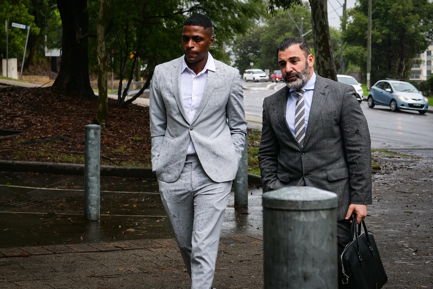 A Colombian soccer player walking into court with his lawyer.
