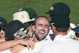 The Australian cricket team react with bowler Nathan Lyon (centre) after he took the last wicket to give Australia victory on day 5 of the first Test match between Australia and India at the Adelaide Oval