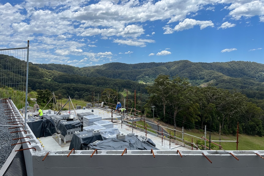 View over looking construction site, with stacks of blocks, mountains and blue sky