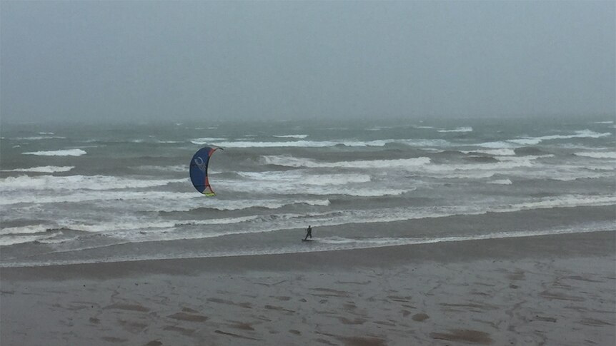 A kitesurfer takes advantage of the windy weather associated with the monsoon.