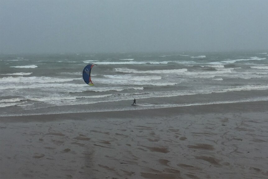 A kitesurfer takes advantage of the windy weather associated with the monsoon.