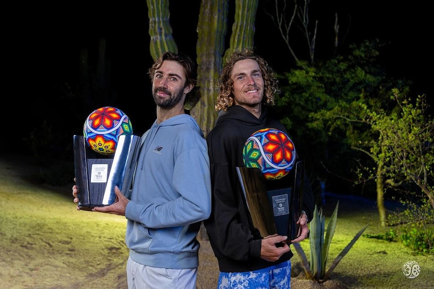 Jordan Thompson and Max Purcell stand back to back with their doubles trophies after winning Los Cabos.