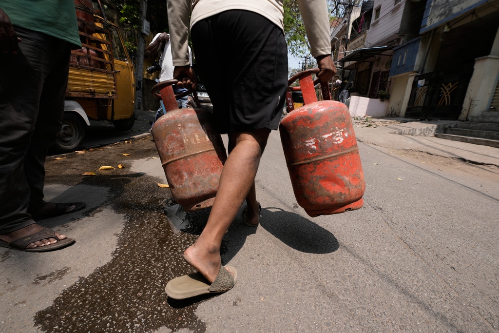Arkadan iki gaz tüpü taşıyan bir adam geliyor.