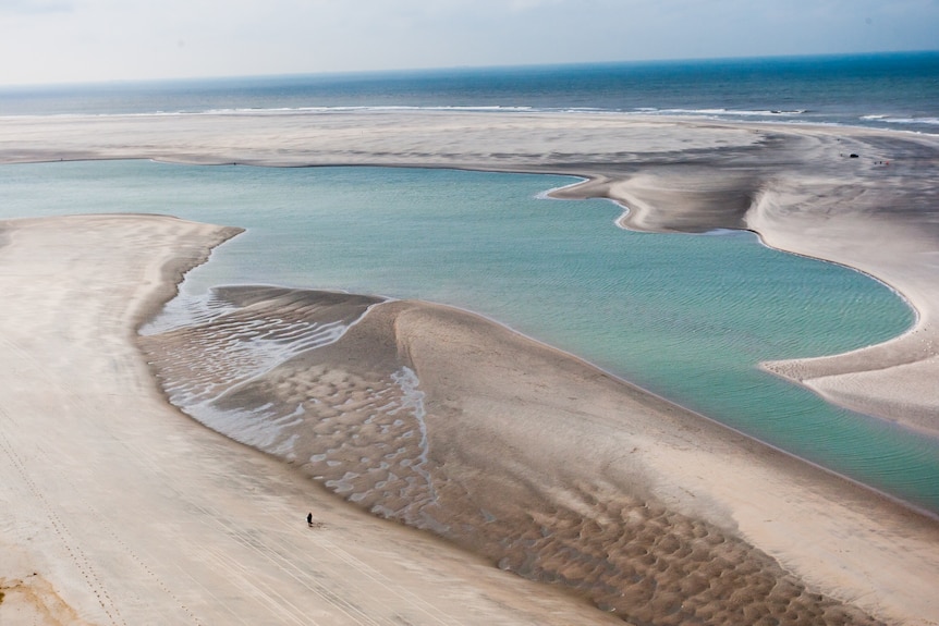 A Dutch lagoon surrounded by sand near the coast.