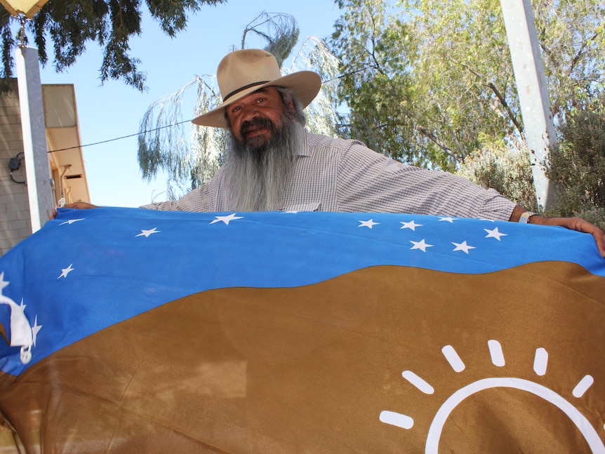 Vince Coulthard proudly holds the Adnyamathanha flag