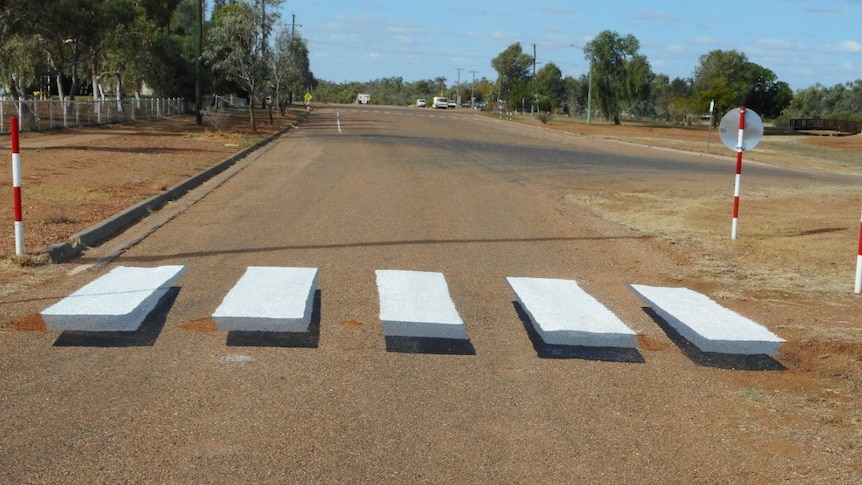 A zebra crossing painted on the road as an optical illusion to look as though the white lines are hovering off the ground