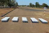 A zebra crossing painted on the road as an optical illusion to look as though the white lines are hovering off the ground