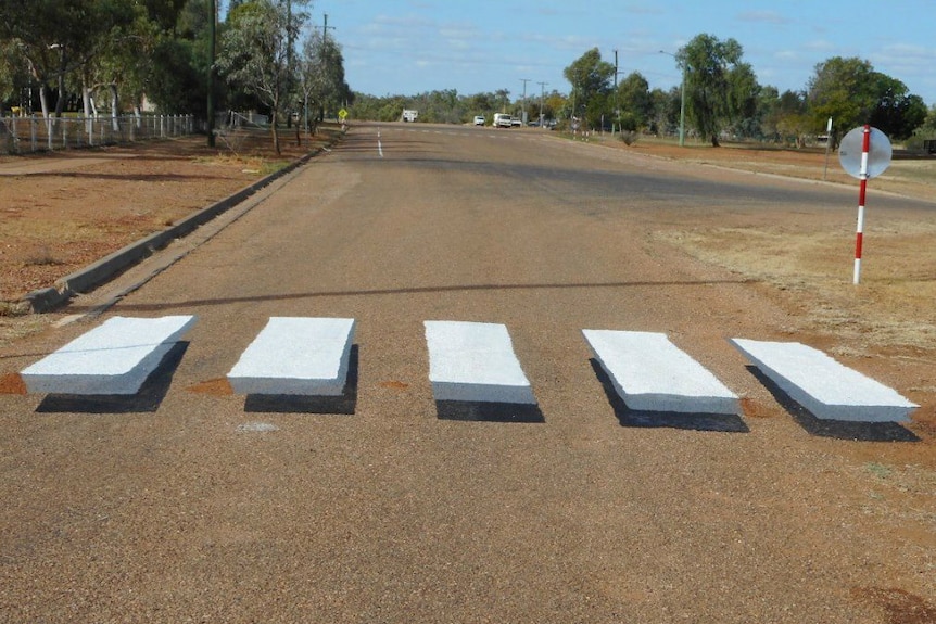 A zebra crossing painted on the road as an optical illusion to look as though the white lines are hovering off the ground