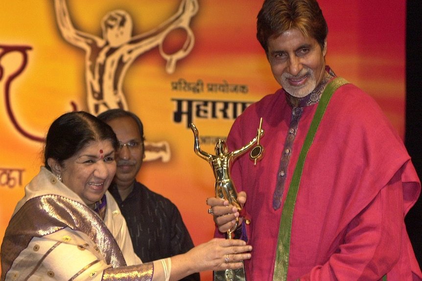 Lata Mangeshkar gives renowned Bollywood actor Amitabh Bachchan an award in this 2005 file photo.