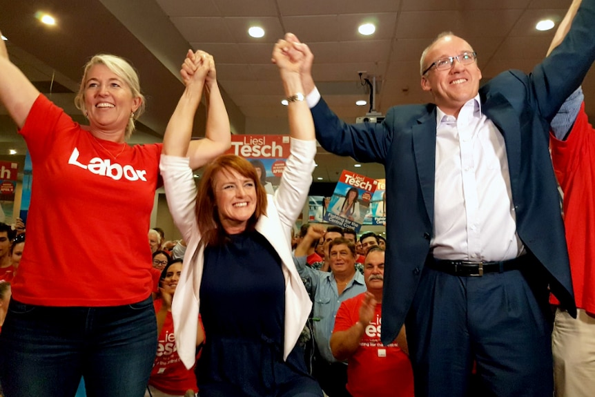 tesch, foley, and another lady with their hands in the air.