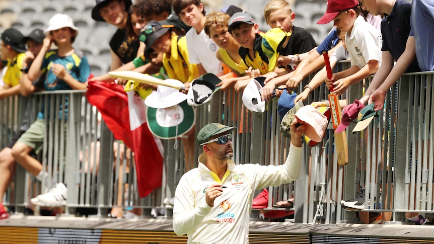 Australia bowler Nathan Lyon signs autographs for fans during a Test against the West Indies.