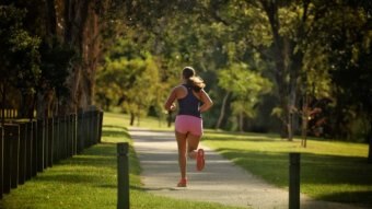 A woman runs along a track.