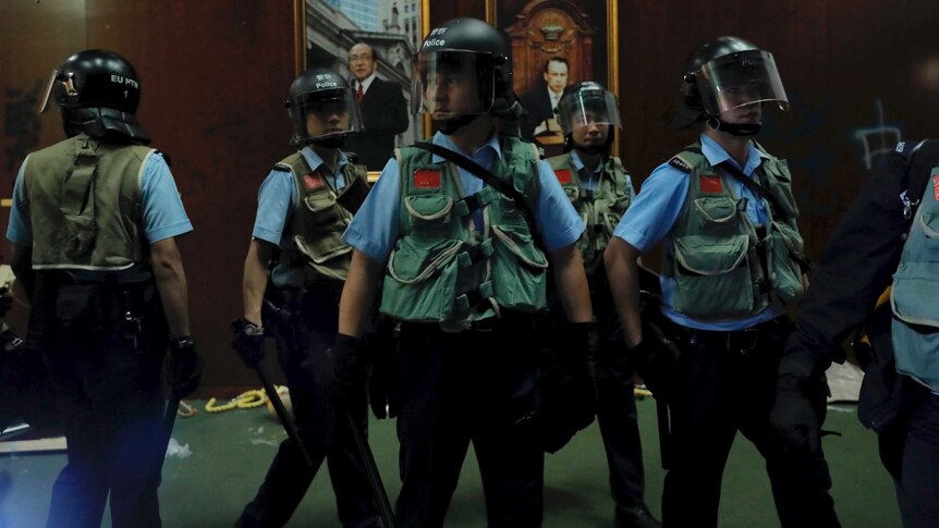 Police officers with protective gear retake the meeting hall of the Legislative Council in Hong Kong.