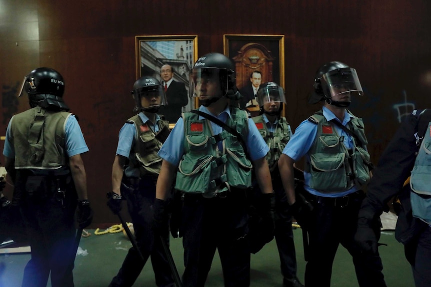 Police officers with protective gear retake the meeting hall of the Legislative Council in Hong Kong.