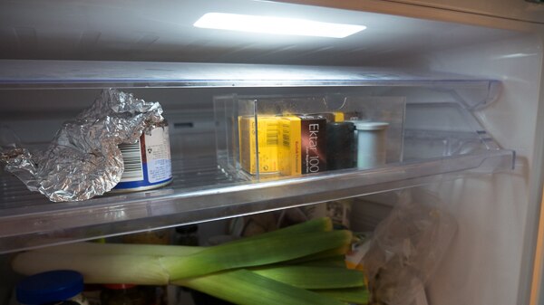 Several canisters of film on the top shelf of Ellie's fridge.