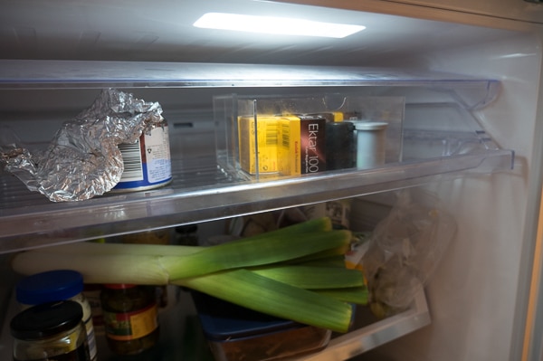 Several canisters of film on the top shelf of Ellie's fridge.