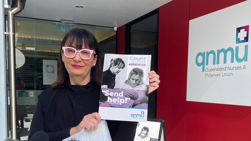 Queensland Nurses and Midwives' Union (QMNU) secretary Kate Veach with pamphlet that says 'Send help' at press conference