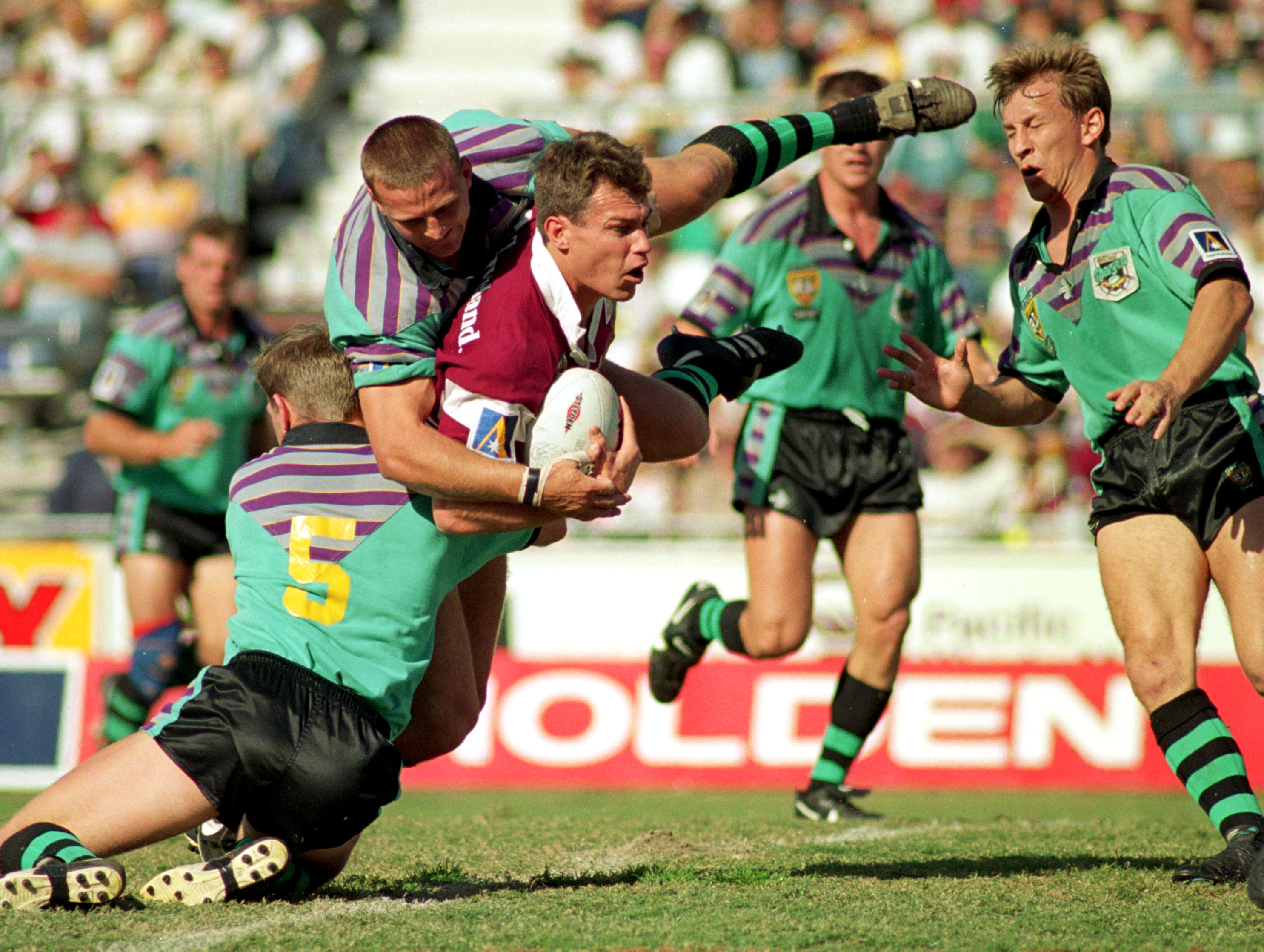 A man runs the ball during a rugby league match 