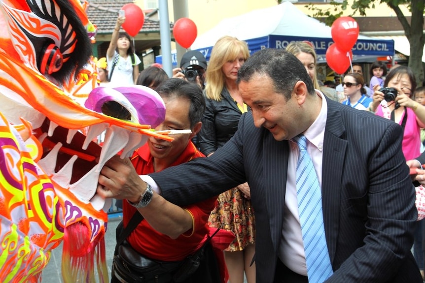 a man looking intently at a festive chinese dragon