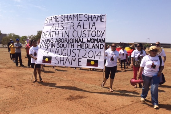 Holding a large sign saying shame on deaths in custody are protesters in South Hedland