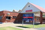 Brick building next to talk white carport with a blue sign out the front that says "Deniliquin Hospital".