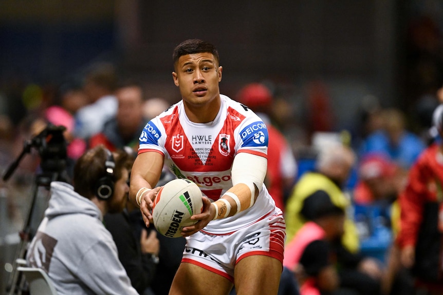 A man passes the ball during a rugby league match