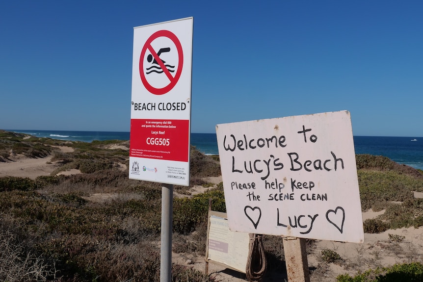 A beach with a sign saying it has been closed 