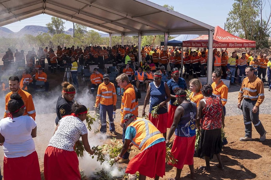 Mine workers watching Traditional Owners performing smoking ceremony