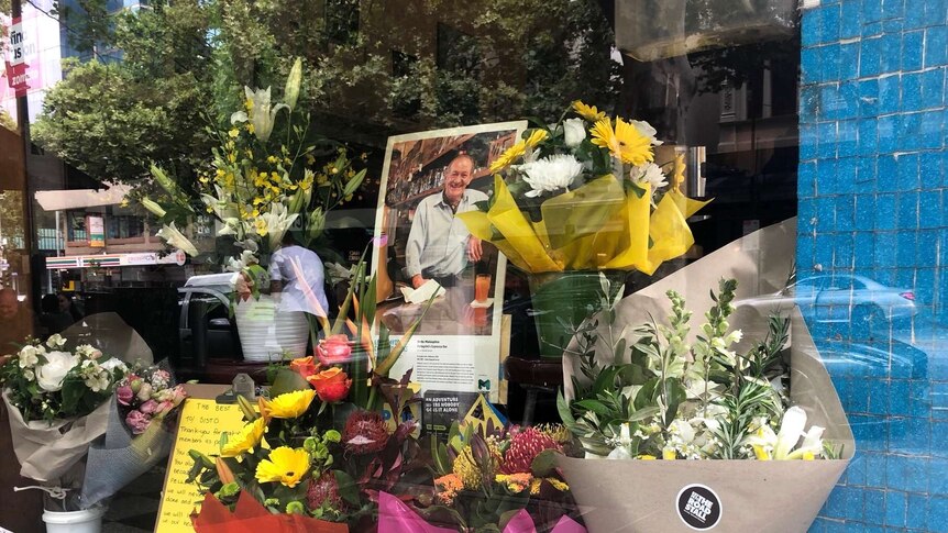 The window of Pellegrini's Espresso Bar in Melbourne with flowers and a tribute to co-owner Sisto Malaspina.