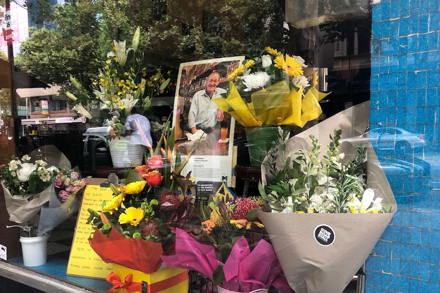 The window of Pellegrini's Espresso Bar in Melbourne with flowers and a tribute to co-owner Sisto Malaspina.