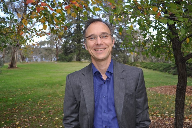 Frank Jotzo wears a blue shirt and grey suit jacket.