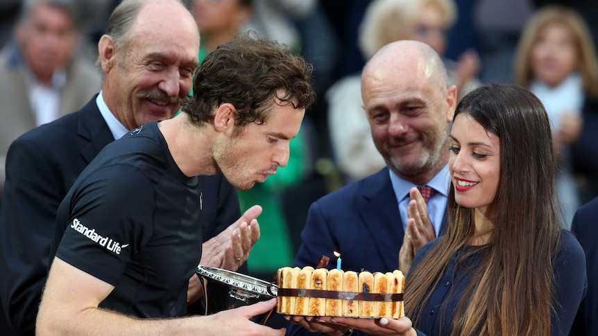 Andy Murray blows out the candle on his birthday cake after winning the Rome Masters final.