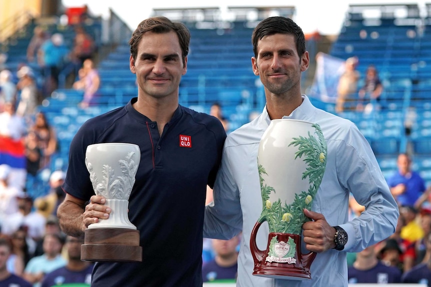 Roger Federer and Novak Djokovic poses with trophies at an ATP World Tour event in Ohio.