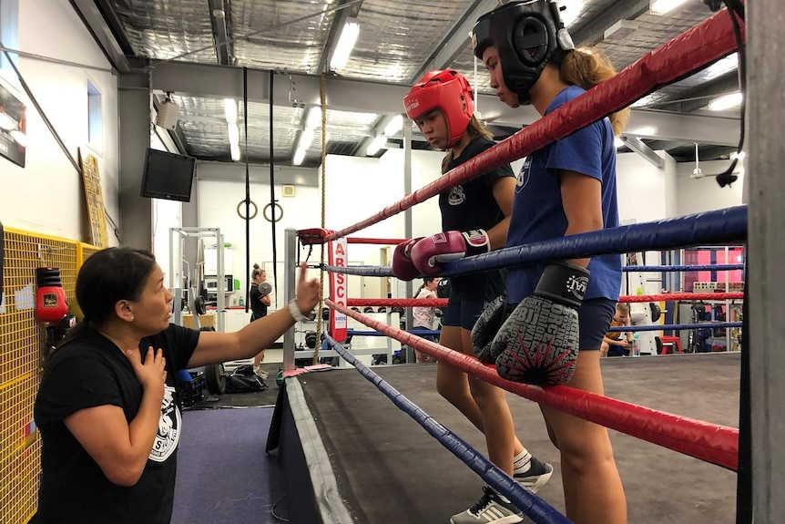 Shara Romer coaching two girls at her boxing gym.