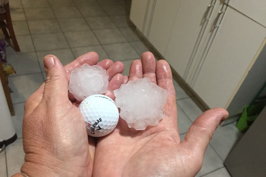 Rockhampton resident shows giant hail next to a golf ball after a storm battered her property.
